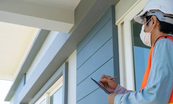 Licensed mold inspector documenting exterior siding conditions on a West Palm Beach home