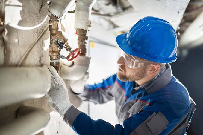 Technician inspecting plumbing and water lines to identify the source of a water intrusion